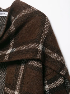 Detailed macro view showing the thick brushed texture and woven check pattern of the coat