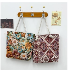 Detail showing two canvas tote bags with floral embroidery and geometric patterns