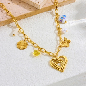 Gold stainless steel layered necklace featuring ceramic floral, butterfly and heart charms