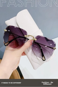 Detail of rimless sunglasses with purple gradient lenses and gold geometric accents