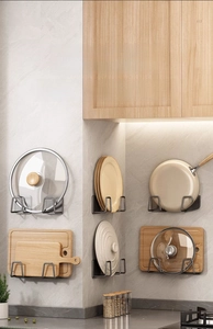 Detail showing wall-mounted gun grey rack storing lids and wooden cutting boards
