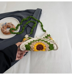 Close-up of handmade crochet sunflower shoulder bag with green straps and floral texture