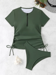 Detail of dark green two-piece tankini set with zip-up top and drawstring side ruching