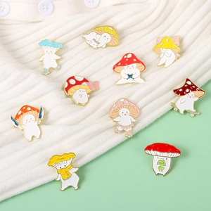 Set aus kreativen Pilz-Emaille-Pins mit verschiedenen Comic-Designs auf einem weißen Pullover