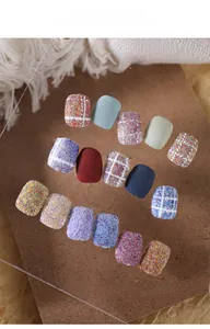Macro shot of 14-piece plaid and glitter nail art patches on a clear display board