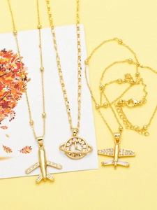 Detailed close-up of gold airplane and celestial clock pendants with sparkling zircons