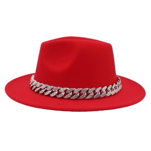 Close-up of a red fedora hat featuring a chunky silver chain with colorful rhinestones