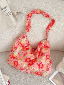 Spacious floral canvas tote bag with vibrant summer flower patterns on a soft sofa