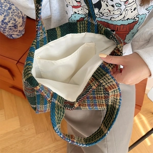 Macro detail of the plaid tote bag interior showing the white lining and open inner pocket