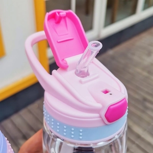 Close-up of pink and blue plastic straw cup lids with textured silicone rings