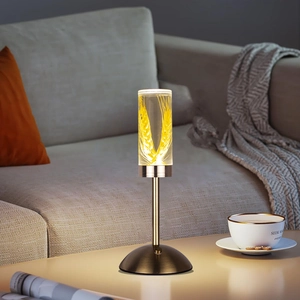 Modern acrylic table lamp with golden wheat detail in a cozy living room setting