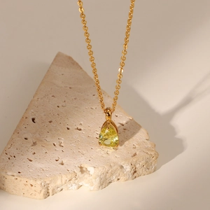 Detailed close-up of 18K gold plated necklace with pear-shaped yellow zircon pendant