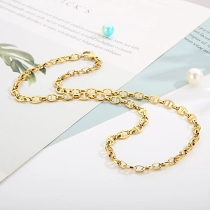 Flat lay of a gold stainless steel pig nose chain necklace with elegant pearl accents