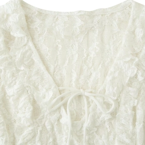 White lace V-neck top with ruffled edges and front bow tie detail for a feminine look