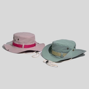 Detail of outdoor sun hats in pink and green with adjustable wind cords and vents