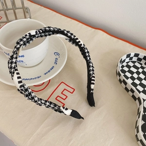 Detail of a braided houndstooth headband with black and white fabric texture and pattern