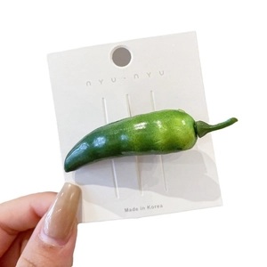 Fermaglio per capelli a peperoncino verde realistico su carta espositiva bianca