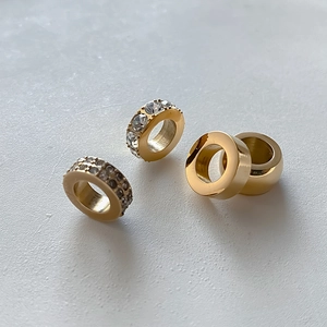 Détail de quatre perles d'espacement dorées en acier inoxydable avec cristaux pour bijoux