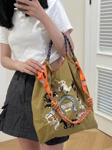 Olive nylon tote bag with horse embroidery and blue rope straps in a lifestyle mirror shot