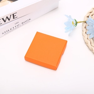 Detail view of square orange jewelry gift box with textured orange peel finish and lid