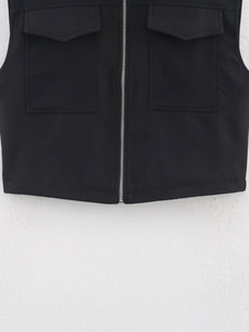 Detailed view of black utility vest featuring metal zipper and symmetrical flap pockets