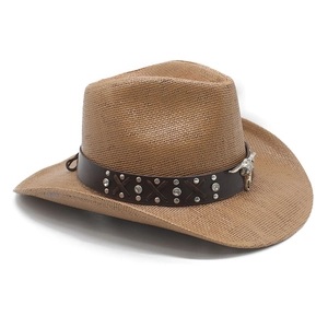 Détail d'un chapeau de paille western avec bande en cuir et pendentif tête de taureau