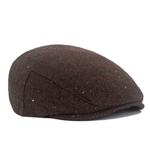 Detail of dark brown herringbone tweed newsboy cap with colorful flecked wool texture