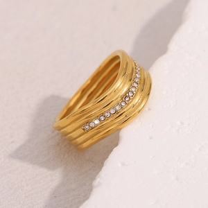 Dettaglio ravvicinato di un anello multistrato placcato oro 18K con file di zirconi lucidi