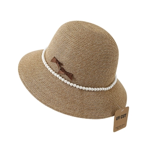 Brown straw sun hat with pearl chain and bow detail featuring UV protection