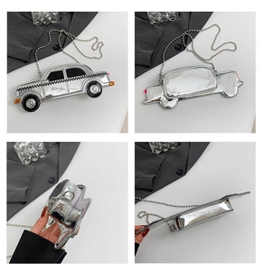 Detail view of silver car shaped handbag with zipper opening and ball chain strap