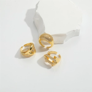 Three gold luxury adjustable rings with crystals and pearl accents on white stone