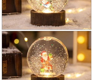Détail d'une boule à neige Père Noël avec base LED chaude et paillettes dorées brillantes