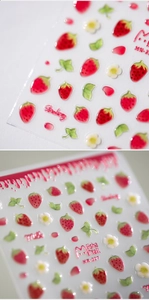 Macro detail of 3D embossed strawberry and floral nail stickers with matte finish