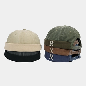 Dettaglio di berretti docker vintage multicolore con logo R in metallo e fibbie