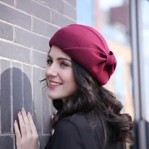 Elegant wine red wool beret for women with a vintage bow detail in an outdoor setting
