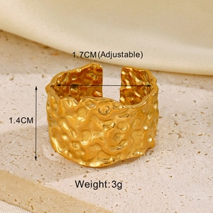 Detailed view of adjustable gold-colored hammered metal ring on natural stone background