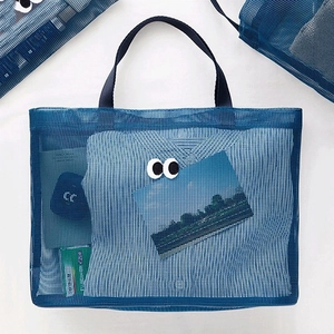 Large blue mesh beach bag with handle featuring cute eye embroidery on white background
