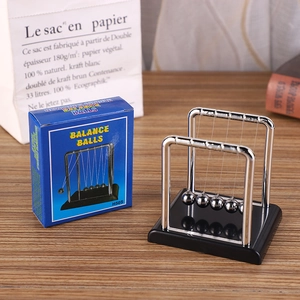Newton's Cradle balance balls on wooden desk with blue product packaging box