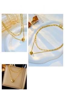 Detail view of double-layer gold titanium necklace with faceted bead and paperclip chain