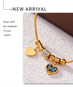 Detail of 18K gold-plated snake chain bracelet with colorful crystal heart and zircons