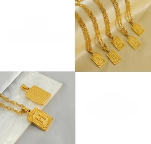 Detailed macro view of 18K gold plated stainless steel initial pendant necklace set