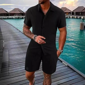 Men's summer casual black short sleeve shirt and beach shorts set in tropical resort setting