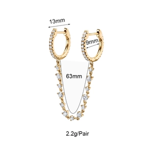 Détail de boucles d'oreilles dorées avec zircons montrant 63mm de long et 2,2g de poids