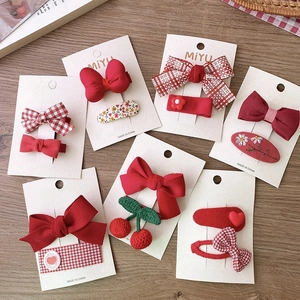 Détail de 6 barrettes festives rouges avec nœuds, cerises et broderies florales