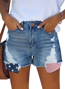 Détail d'un short en jean usé avec motif drapeau américain et finitions effilochées