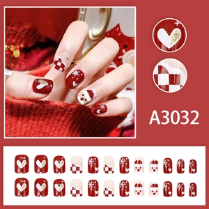 Short festive Christmas press-on nails with red heart, snowflake, and Santa motifs