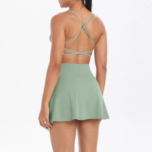 Detail eines salbeigrünen Yoga-Sets mit überkreuztem Sport-BH und Tennisrock mit hoher Taille