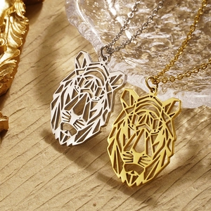 Detail of geometric cutout tiger head pendants in gold and silver stainless steel