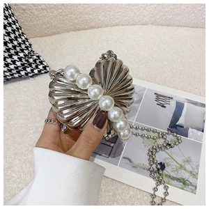 Detail of heart-shaped metallic box bag with pearl inlay and round bead chain