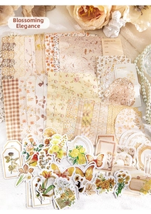 Detail of vintage scrapbooking kit with floral stickers, butterfly die-cuts, and textured paper